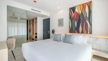 Ein modernes Hotelzimmer mit einem großen Bett, einem Schreibtisch und einem Kleiderschrank.