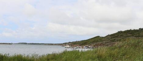 A picnic table by a lake with boats in the background.