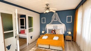 A bedroom with a bed, a ceiling fan, a nightstand, and a window with curtains. - Cunda Bebekli Ev (Ayvalik)
