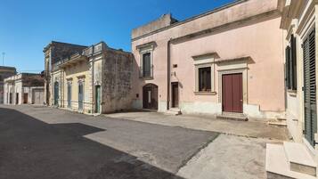 Eine ruhige Straße mit historischen Gebäuden, darunter ein Haus mit roter Tür und der Hausnummer 101.