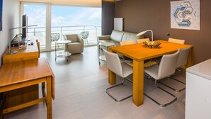 Ein modernes Wohnzimmer mit Essbereich, einer Couch und einem Balkon mit Blick.