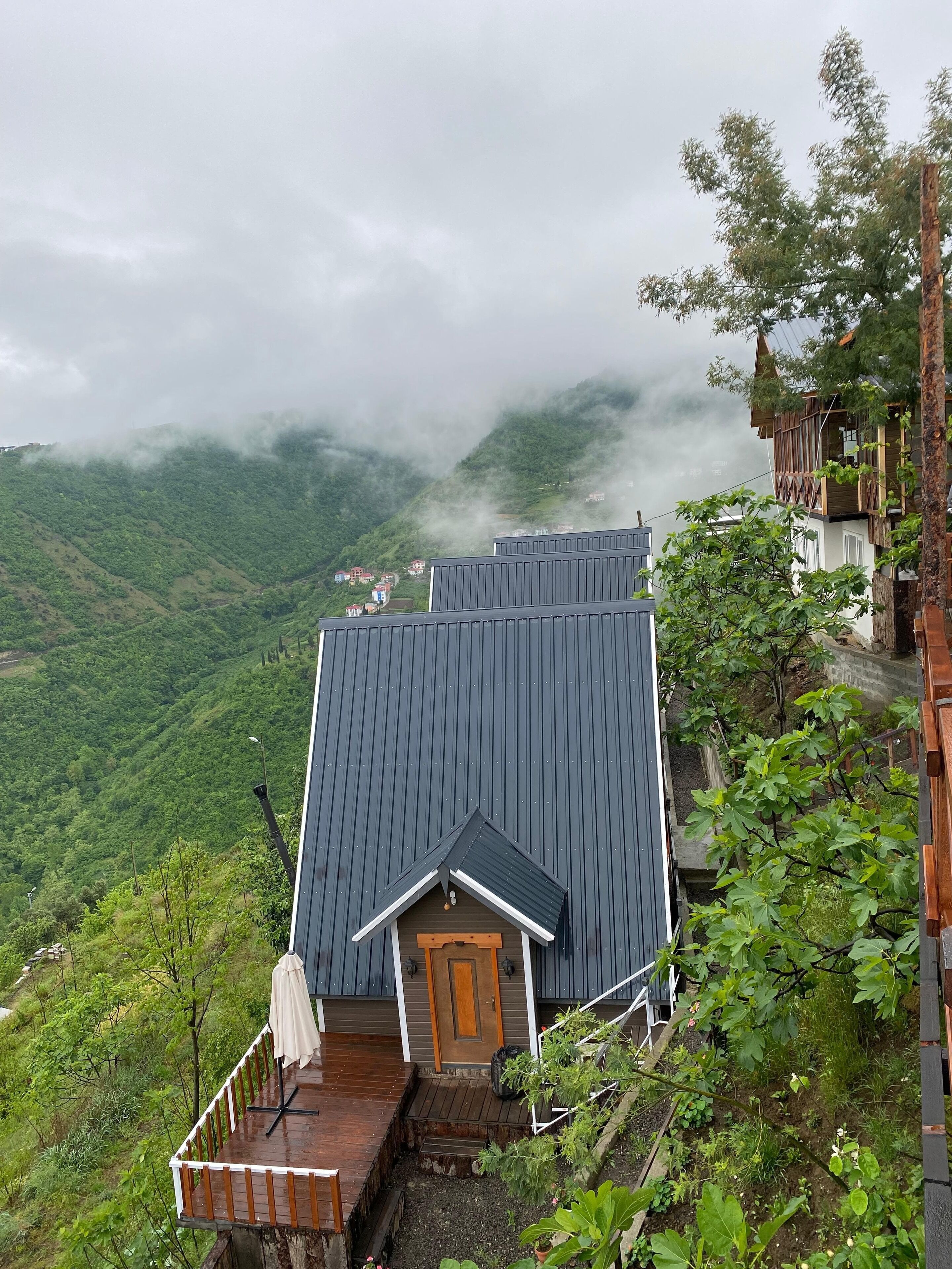 A mountain cabin with a wooden door and a small porch.