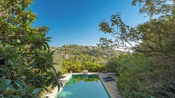 Ein Pool mit Blick auf eine hügelige Landschaft.