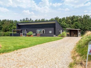 A modern two-story building with a gravel driveway leading to a covered entrance. - 5 Star Holiday Home in Hemmet (Hemmet)
