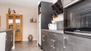 A modern kitchen with grey cabinets, a built-in oven, and a coffee maker. - 5 Star Holiday Home in Hemmet (Hemmet)