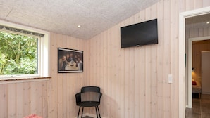 A room with a bed, a chair, a television, and a window with a view of greenery. - 5 Star Holiday Home in Hemmet (Hemmet)
