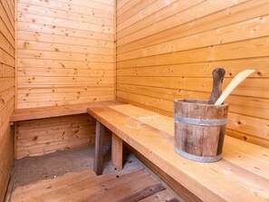 A wooden sauna with benches and a wooden bucket with a ladle. - 5 Star Holiday Home in Hemmet (Hemmet)