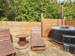 A wooden deck with a hot tub, lounge chairs, and a table. - 5 Star Holiday Home in Hemmet (Hemmet)