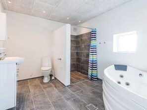 A modern bathroom with a shower, toilet, and a bathtub. - 5 Star Holiday Home in Hemmet (Hemmet)