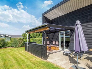 A patio area with a pergola, outdoor seating, and a covered table. - 5 Star Holiday Home in Hemmet (Hemmet)