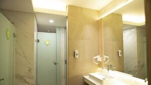 A modern bathroom with a large mirror, two sinks, and a shower area. - Whiz Capsule Thamrin Jakarta (Jakarta)