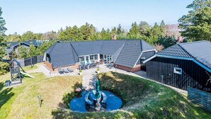 A residential property with a swimming pool, a play area, and a large barn.
