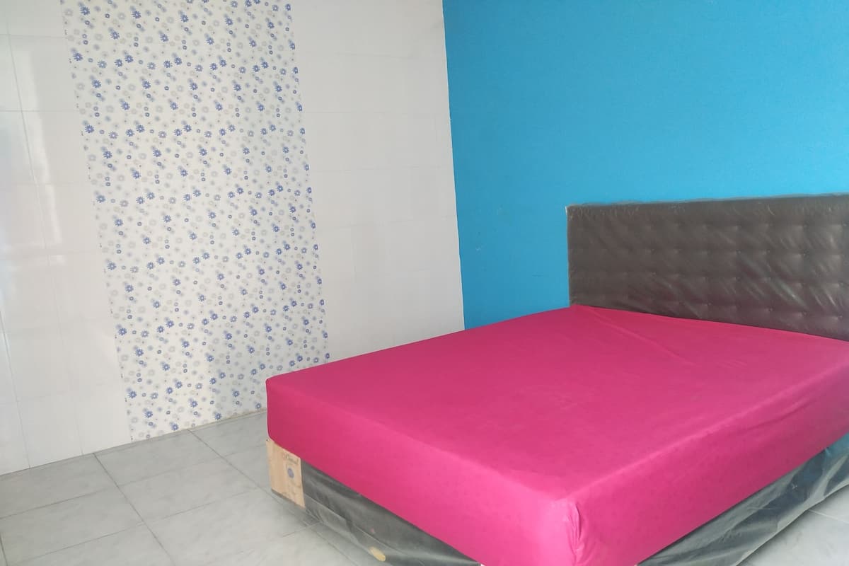 A room with a bed, a patterned wall, and a blue wall.