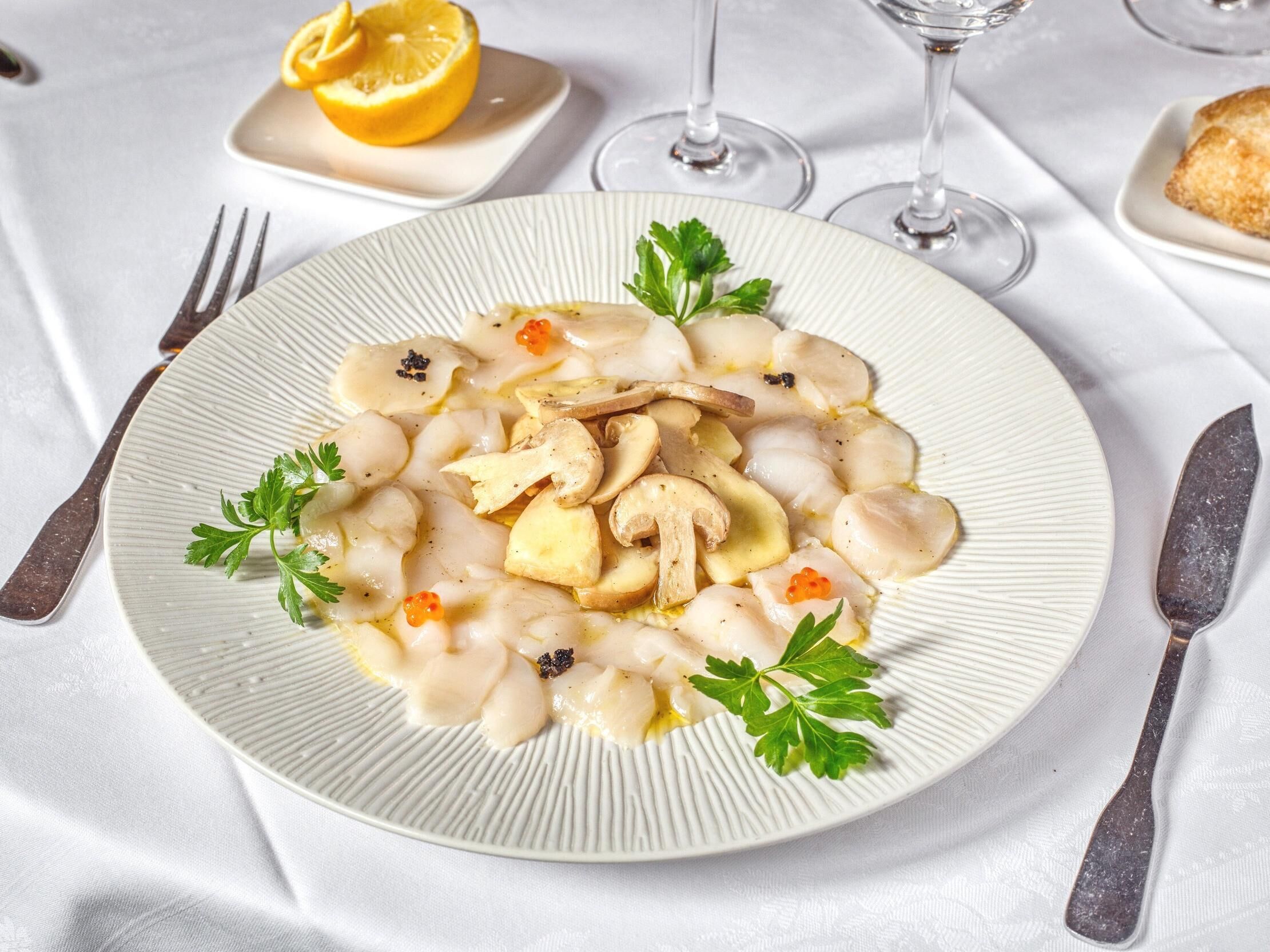 A plate of food with mushrooms and caviar, garnished with parsley, on a white plate.