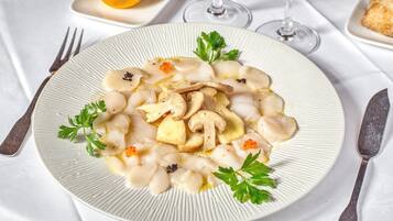 A plate of food with mushrooms and caviar, garnished with parsley, on a white plate.