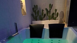 A spa tub with a green light, a cactus wall, and a brick wall. - 1 Bedroom Bed & breakfast in Grottaglie (Grottaglie)