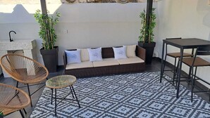 A cozy outdoor seating area with a sofa, two wicker chairs, a small round table, and a patterned rug. - 1 Bedroom Bed & breakfast in Grottaglie (Grottaglie)