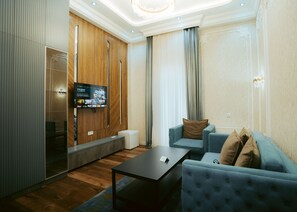 Habitación triple familiar | Área de sala de estar | Televisión y piso con calefacción 