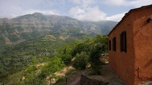 Un edificio rústico con un camino de piedra que lleva a un paisaje montañoso.