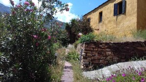 Un edificio rústico con un muro de piedra y un camino empedrado que conduce a él.