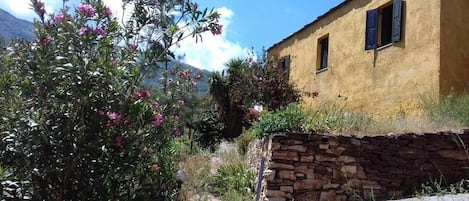 Un edificio rústico con un muro de piedra y un camino empedrado que conduce a él.