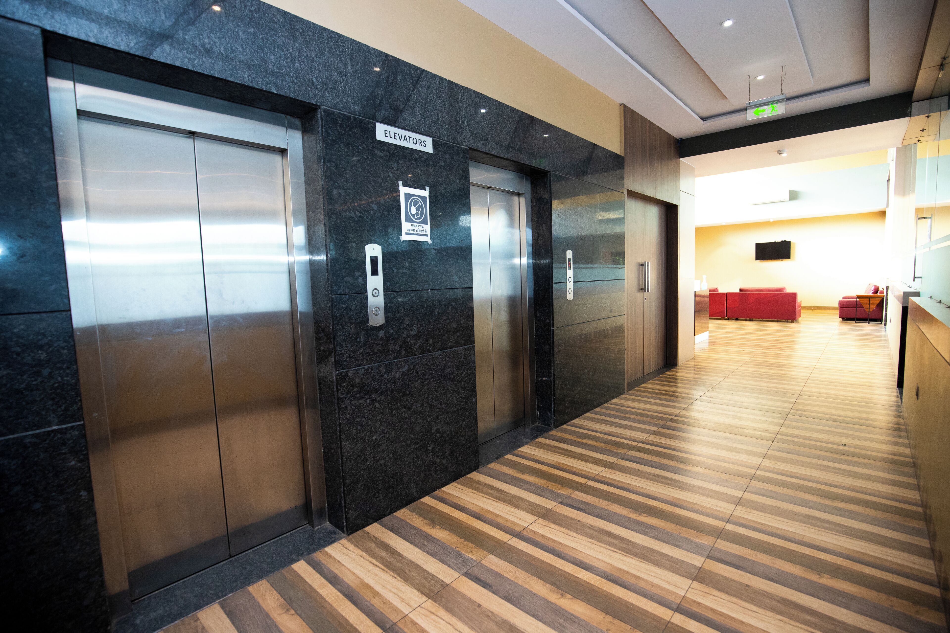 A hallway with elevators and a reception area.