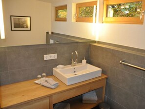 A bathroom with a rectangular sink, wooden vanity, and a towel rack. - Suite Nuss Modern Retreat (Bad Wiessee)