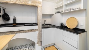 Una cocina moderna con armarios blancos, encimeras negras y salpicadero de granito.