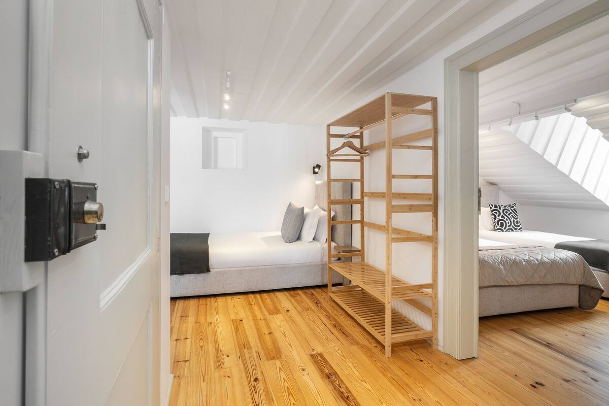 Une chambre moderne avec un lit en mezzanine, une étagère en bois et un escalier menant à un niveau supérieur.