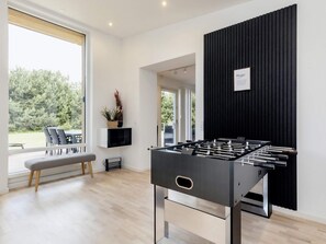 A modern room with a foosball table, a bench, and a view of the outdoors. - 4 Star Holiday Home in Vaeggerlose (Vaeggerlose)