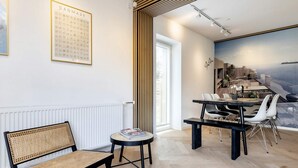 A modern interior with a dining area, a bench, and a wall-mounted poster. - 4 Star Holiday Home in Vaeggerlose (Vaeggerlose)