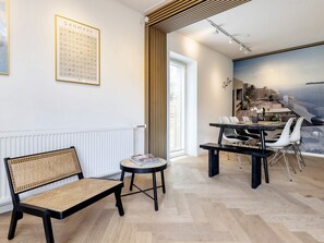 A modern interior with a dining area, a bench, and a wall-mounted poster. - 4 Star Holiday Home in Vaeggerlose (Vaeggerlose)
