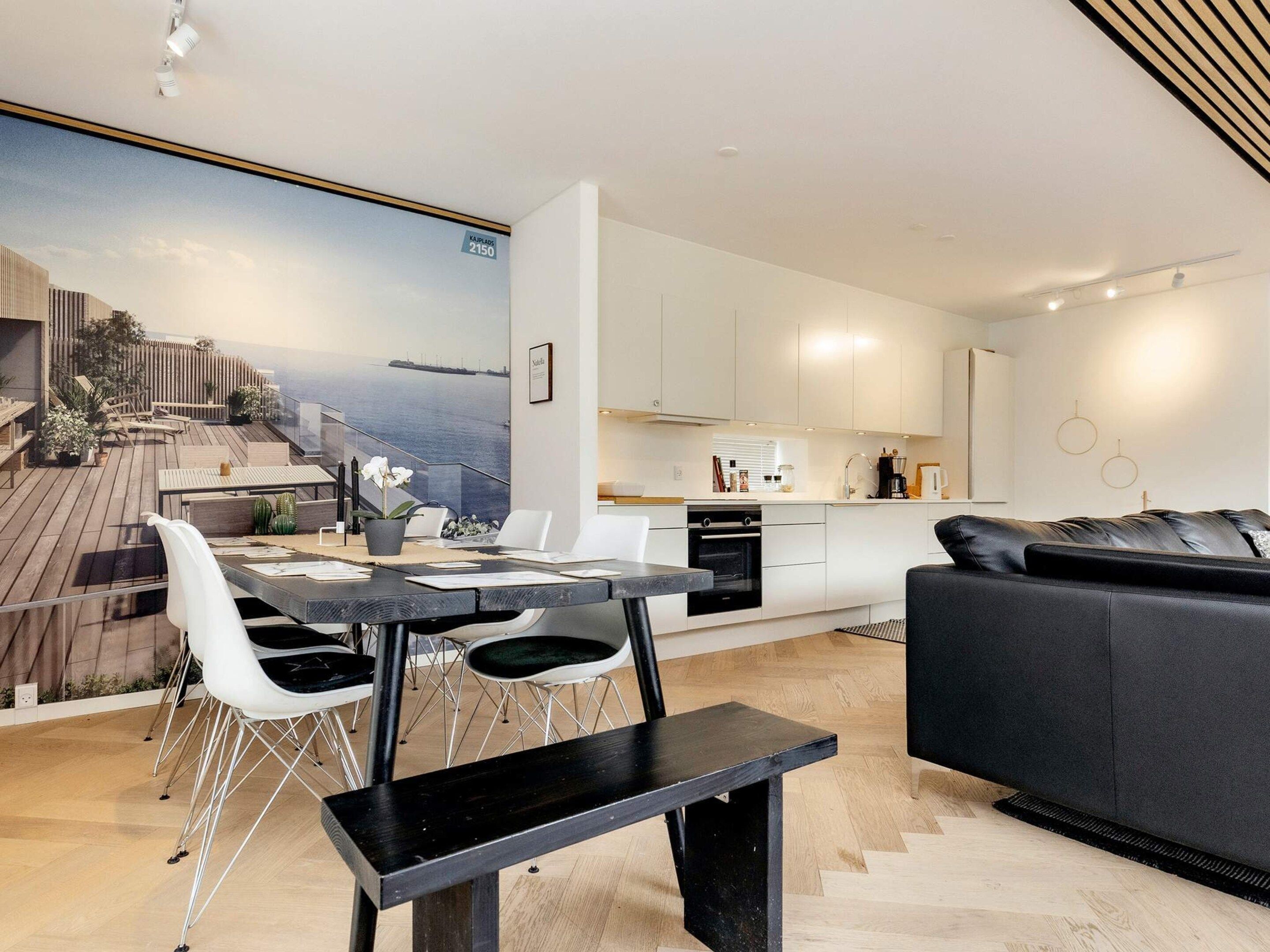 A modern interior with a dining area, kitchen, and seating space.