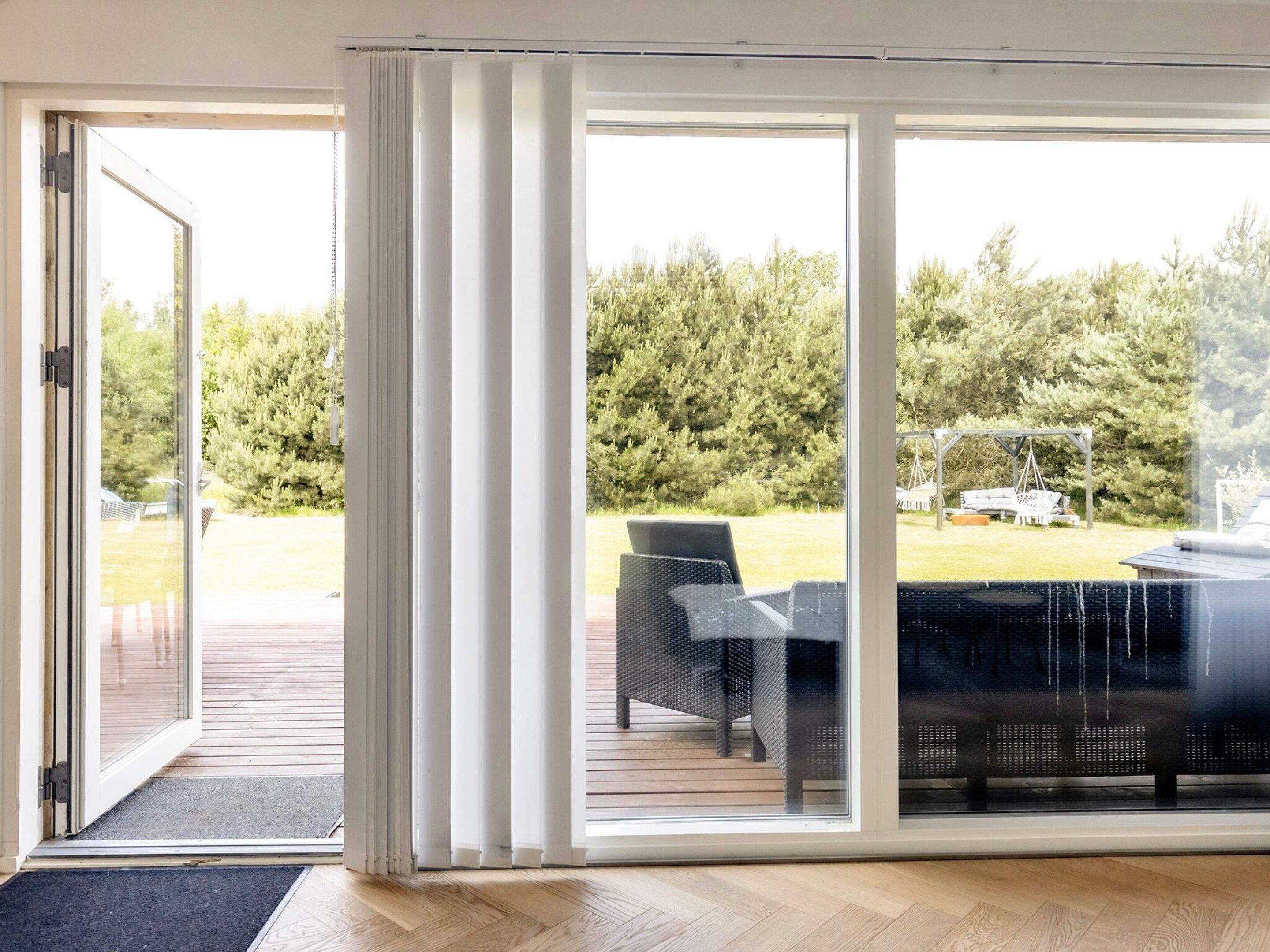 A room with a sliding glass door leading to an outdoor area with a patio and outdoor furniture.