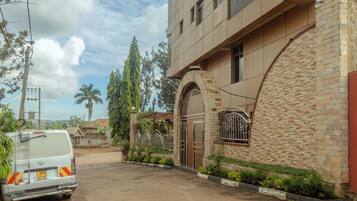 A residential building with a stone facade, a gated entrance, and a parked van.