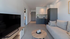 A modern living room with a flat-screen TV, a sofa, and a coffee table. - SithoniaRS Ground Floor Gem in Nikiti (Nikiti)