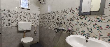 A bathroom with a toilet, sink, and shower.