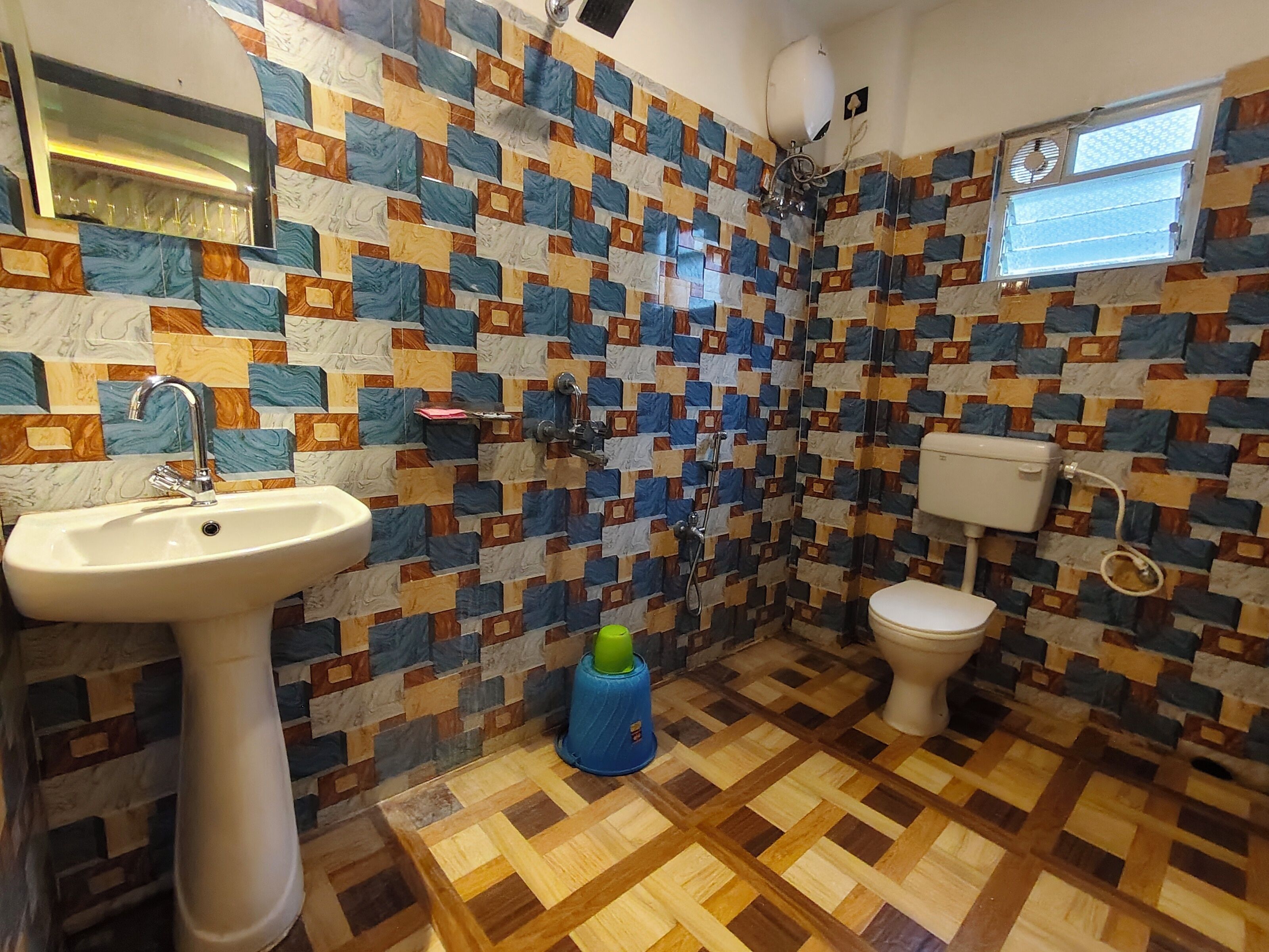 Ein Badezimmer mit gemusterten Fliesen, einem Waschbecken, einer Toilette und einer Duschkabine.