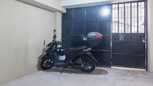 Una motocicleta estacionada en un garaje con una puerta negra y un ventanal.