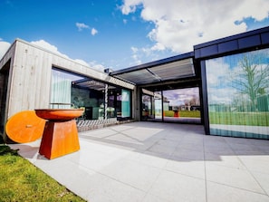 A modern house with a large patio, a wooden wall, and a glass door. - Maison Heurelijk Modern Finished Near Somme-leuze (Somme-Leuze)