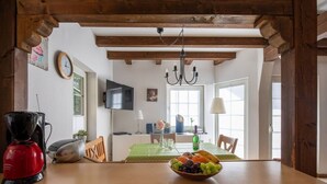 A kitchen with a wooden table, a coffee maker, and a bowl of fruit. - Felsberg Modern Retreat (Eslohe)