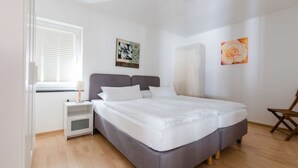 A double bed with a grey headboard and white bedding in a room with wooden flooring. - Felsberg Modern Retreat (Eslohe)