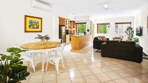 Una sala de estar moderna con comedor, cocina y sofá.