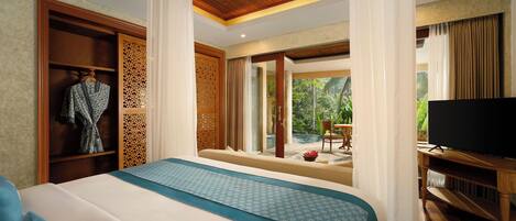 A hotel room with a large bed, a TV, a wardrobe, and a view of the outdoors.