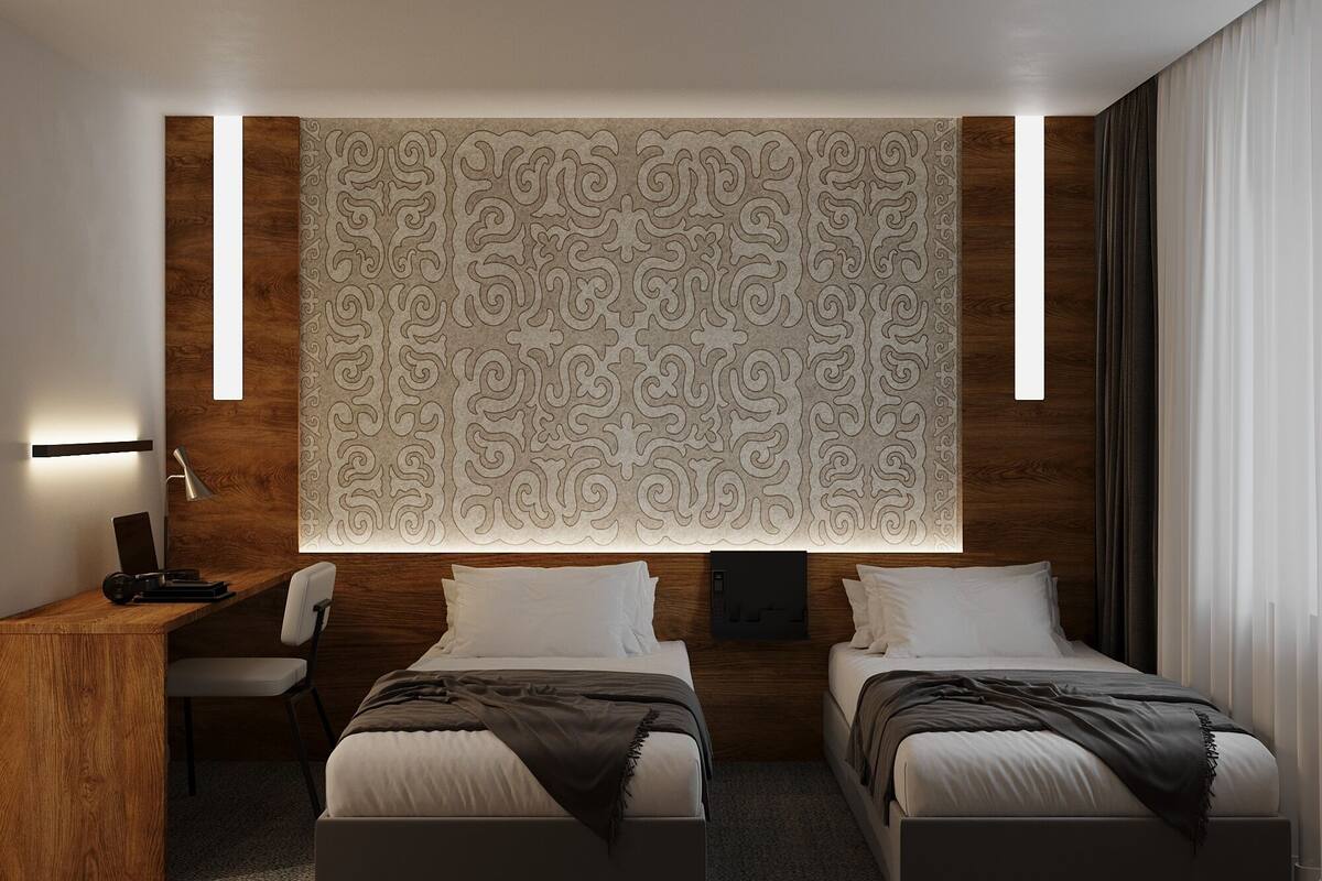 A modern hotel room with a large patterned wall, two beds, a desk, and a chair.