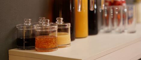 A shelf with various glass containers holding different liquids.