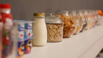Una hilera de recipientes de comida sobre una estantería.