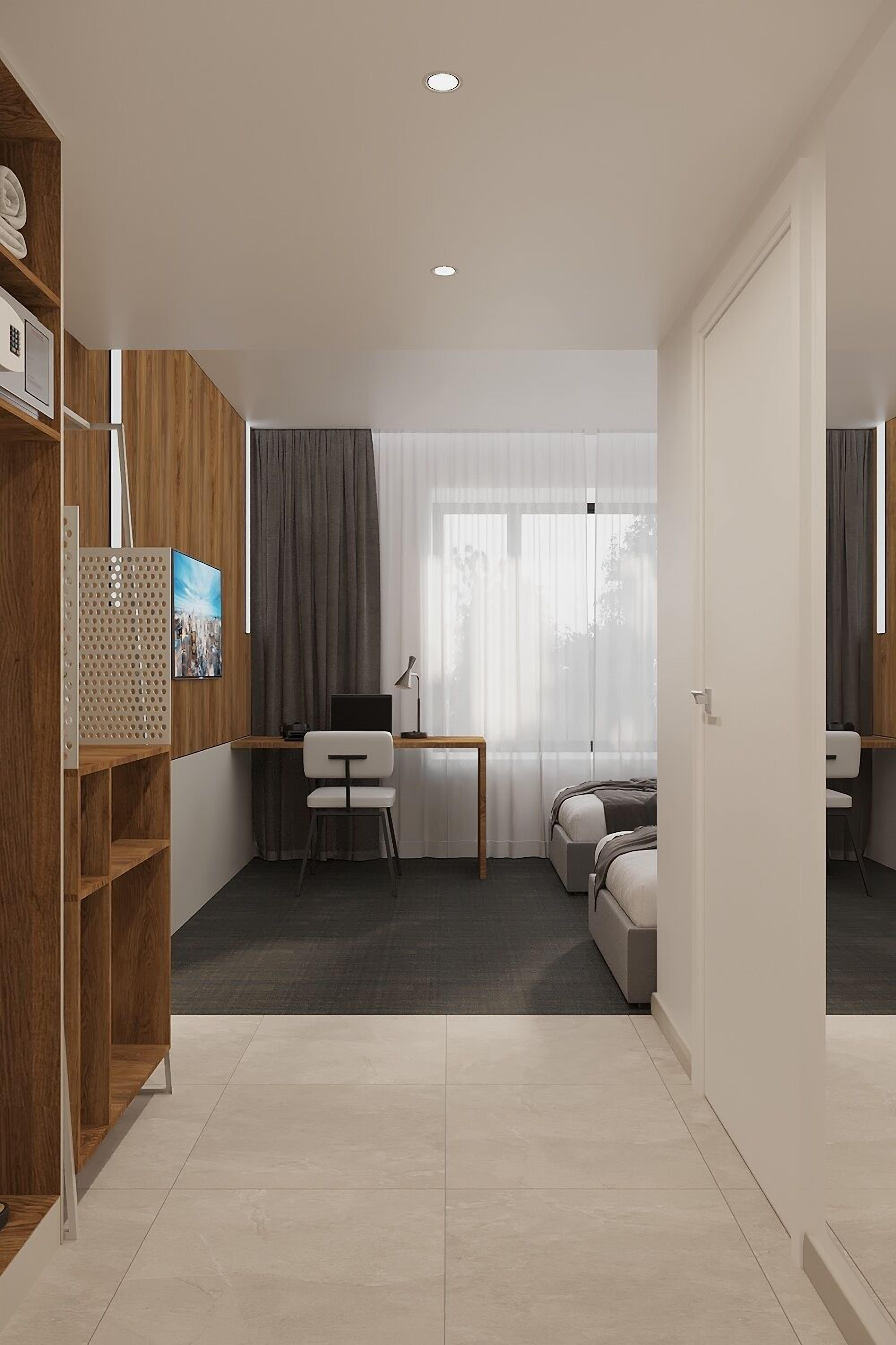 A modern hotel room with a wooden wardrobe, a desk with a chair, a bed, and a large window with curtains.