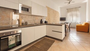 A modern kitchen with a built-in microwave, oven, and a stone backsplash. - 3900 Leccelsa Dimora by Barbarhouse (Lecce)