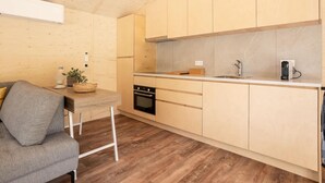 A modern kitchen with wooden cabinets, a built-in oven, and a countertop with a sink. - Nice Holiday Home in Kortgene With Garden (Kortgene)